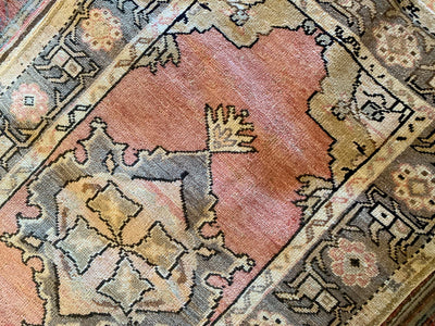 Close up of hand knotting on a small red & orange Guney Turkish rug.