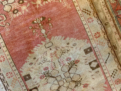 Central medallion on a small red & orange Guney Turkish rug.