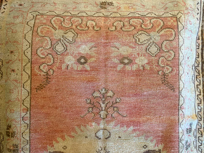 Close up of hand knotting on a small red & orange Guney Turkish rug.