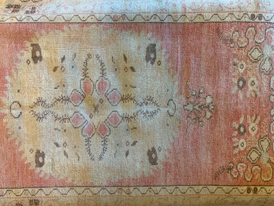 Central white medallion on a small red & orange Guney Turkish rug.
