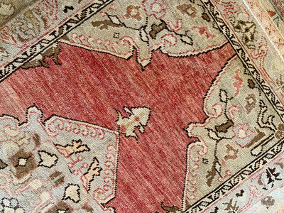 Close up of hand knotting on a vintage small red & orange Guney Turkish rug.