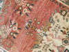 Close up on a hand knotted small red & orange Guney Turkish rug.