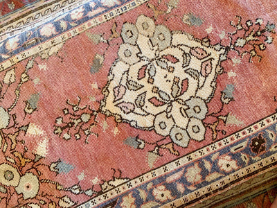 Central medallion on a small red & orange Guney Turkish rug.
