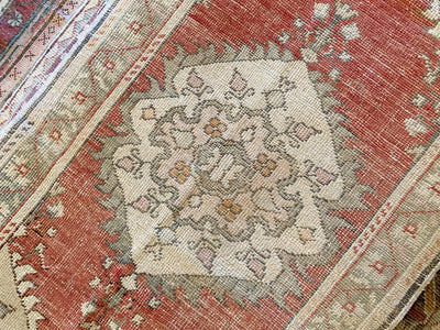 Central medallion on a small red & orange Guney Turkish rug.