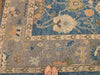 Woman's feet on a blue & green Oushak Turkish area rug.