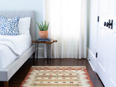 Bedroom with a red & orange small Turkish Kilim rug.