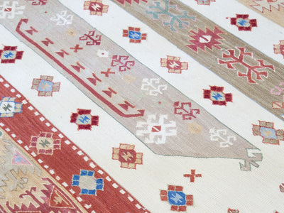 Close of of knots and small medallions on a red & orange small Turkish Kilim rug.