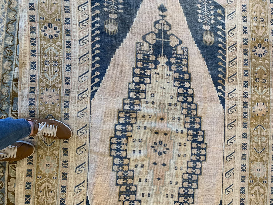 Woman's feet on a blue & green medium Sivas Turkish Rug.