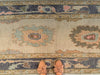 Tan leather flats on a blue & green Turkish runner rug.