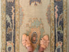 Woman in tan leather flats on a blue & green Turkish runner rug.
