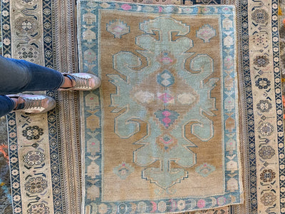 Woman standing on a blue & green small Sivas Turkish Rug.