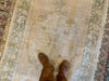 Woman standing on a vintage medium brown & grey Guney Turkish rug.
