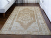 A brown & grey medium sized Maden Turkish rug on the floor.