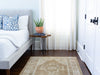 Bedroom with a brown & grey medium sized Maden Turkish rug.