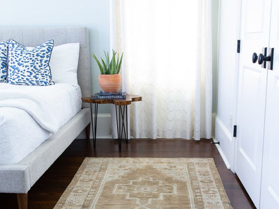 Bedroom with a brown & grey medium sized Maden Turkish rug.