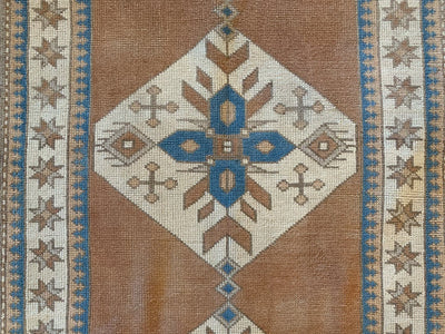 Central medallion pattern on a brown & grey Sultahan runner Turkish rug.