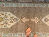 Center of a brown & grey Turkish runner rug featuring two central medallions.