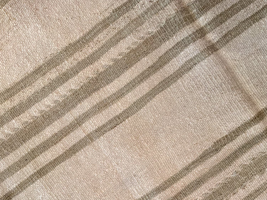 Close up of hand knotting on a brown & grey Turkish rug runner.