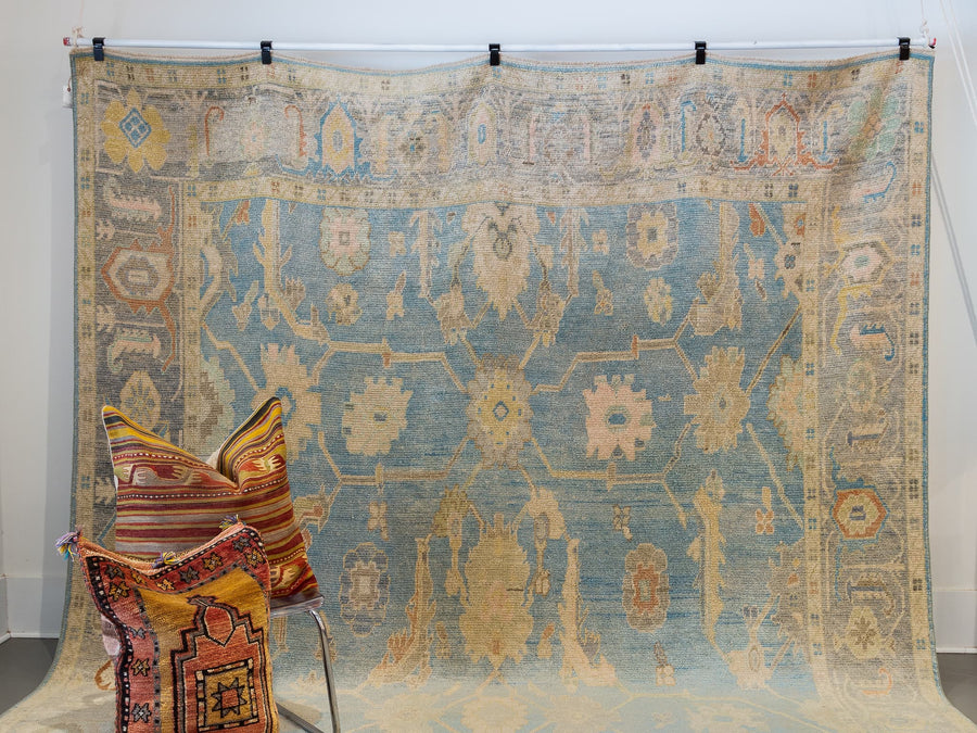 Hanging extra large blue & green Turkish Oushak rug.