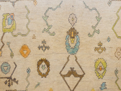 close up of medallions and symbols on an extra large brown & grey Turkish Oushak rug.