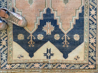 Medium blue green Sivas Turkish Rug with woman foot on rug.