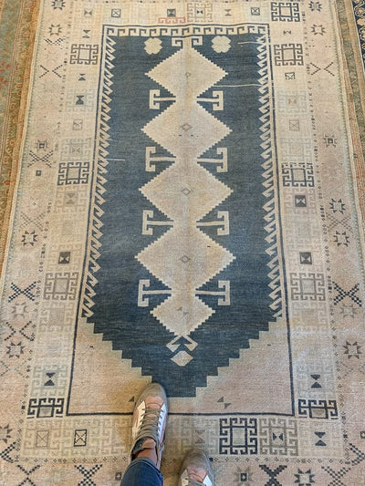 Long view of a brown & grey Sivas Turkish rug with a woman's feet.