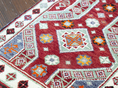 Close up of central medallion on a red & orange extra small Turkish Yastik Rug.