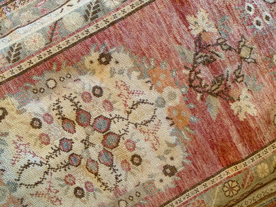 Close up of central knot work on a medium red & orange Guney Turkish rug.