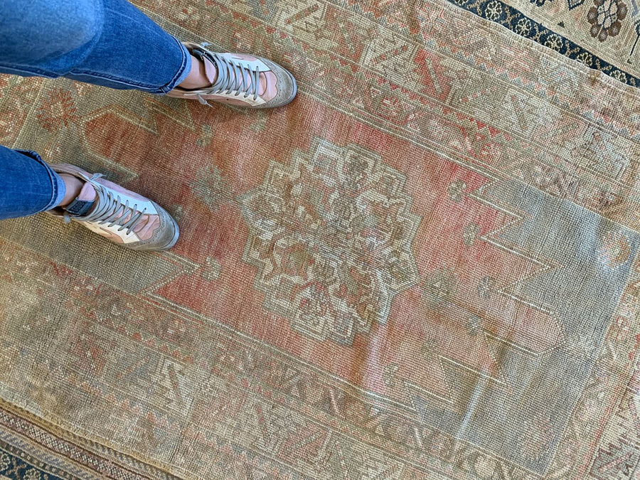 Woman standing on red & orange small Bor Turkish Rug.