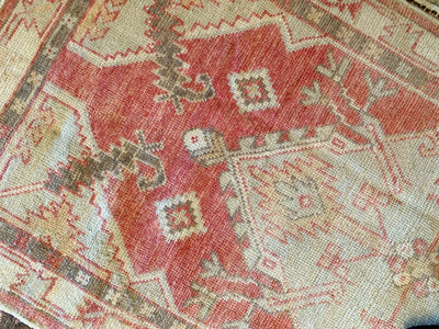 Central medallion and surrounding motifs on a small red & orange Cal Turkish rug.