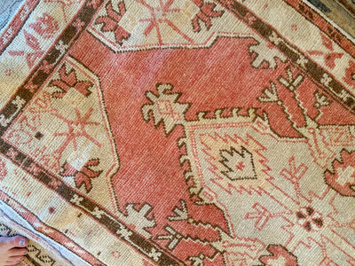 Close up of hand knotting on a small red & orange Cal Turkish rug.