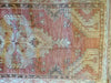 Top down view on a vintage small red & orange Cal Turkish rug.