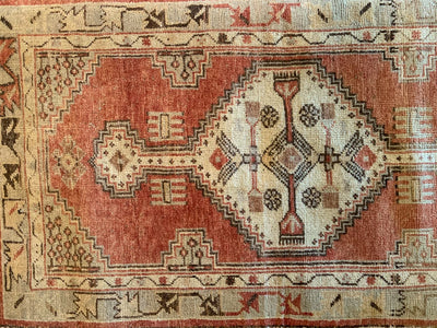 Central medallion on small red & orange Cal Turkish rug.