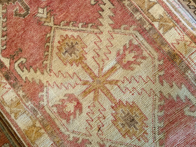 Central medallion on a small red & orange Cal Turkish rug.