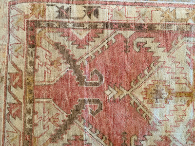 Close up of corner knotting on a small red & orange Cal Turkish rug.