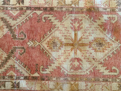Central medallion and border on a small red & orange Cal Turkish rug.