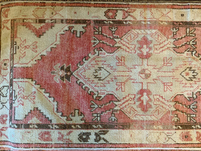 Close up of a small red & orange Cal Turkish rug.