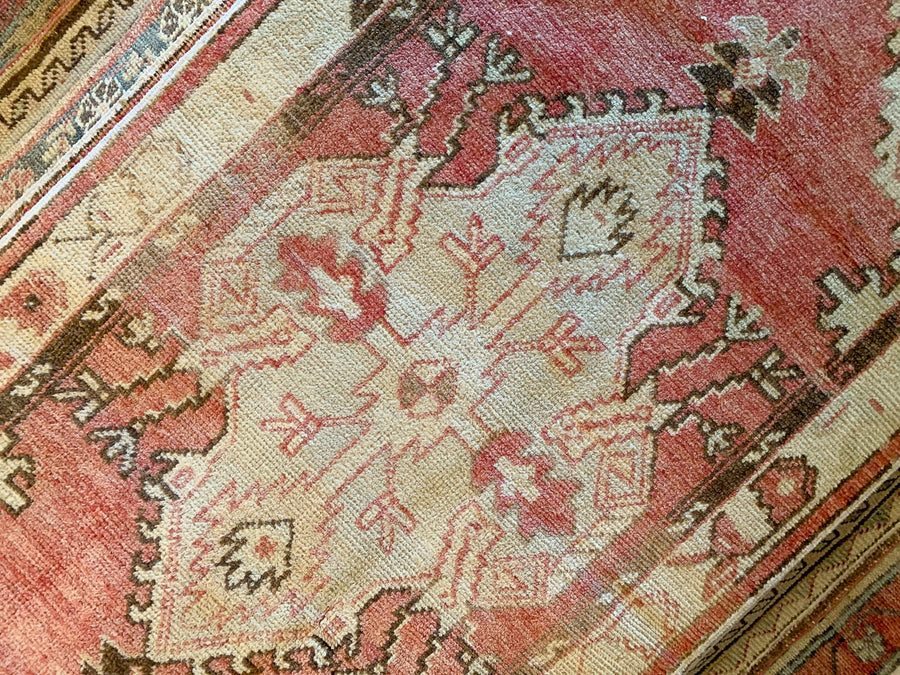 Central medallion on a small red & orange Cal Turkish rug.