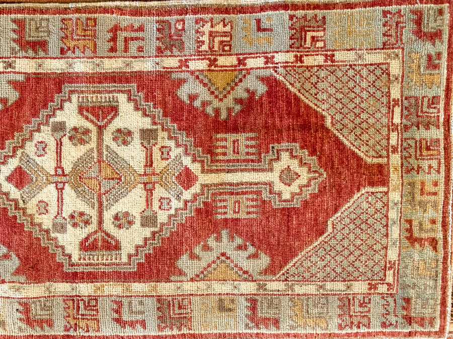 A small red & orange Cal Turkish rug.