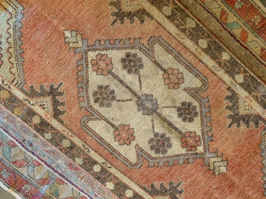 Central medallion on a small red & orange Cal Turkish rug.