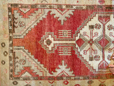 Corner knot work on a small red & orange Cal Turkish rug.