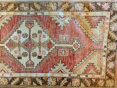 Central motif and border on a small red & orange Cal Turkish rug.