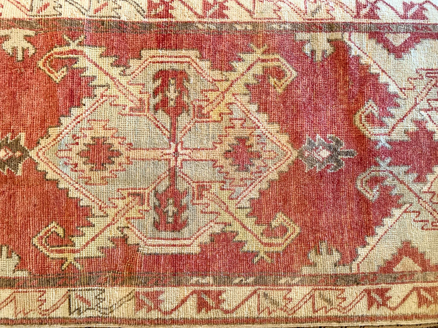 Central medallion on a small red & orange Cal Turkish rug.