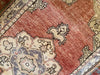 Close up of a small red & orange Guney Turkish rug