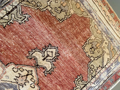 Hand knotting on a small red & orange Guney Turkish rug.