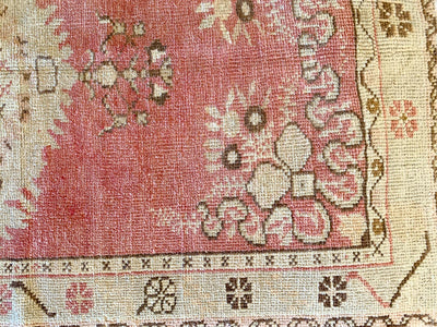 Close up on corner motif on a small red & orange Guney Turkish rug.