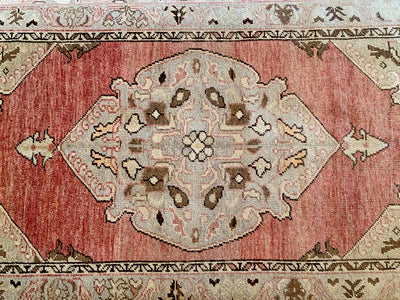 Central medallion on a small red & orange Guney Turkish rug.
