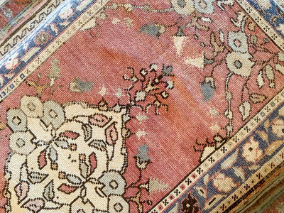 Close up of a small red & orange Guney Turkish rug.