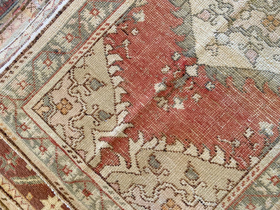 Close up of motif work on a small red & orange Guney Turkish rug.