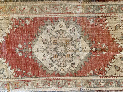 Central medallion and borders on a small red & orange Guney Turkish rug.